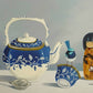 Blue and White Teapot and Doll